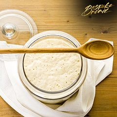 Jar of sourdough starter in the making with flour and water mixture