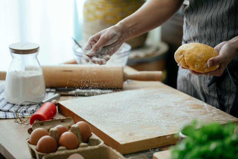 Baker practicing with dough on kitchen counter illustrating Bake It 'Til You Make It baking tips
