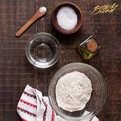 Ingredients in baking sourdough bread including flour, water, and salt on a wooden table in Singapore