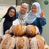People learning sourdough baking techniques in a hands-on class session