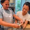 Group attending hands-on sourdough baking class learning techniques from instructor