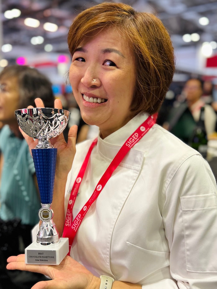 Woman holding a trophy at an event with blurred background